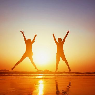 happy couple jumping on the beach
